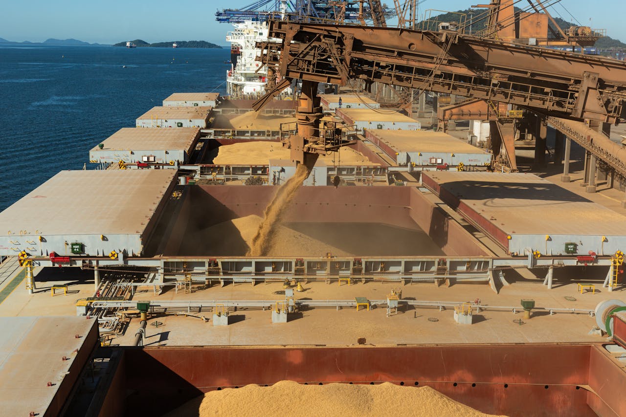 The Art of Drawing Readers In: Your attractive post title goes here Aerial view of a cargo ship loading grain at a bustling industrial port by the sea.